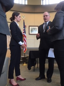 People conferring in room with flag