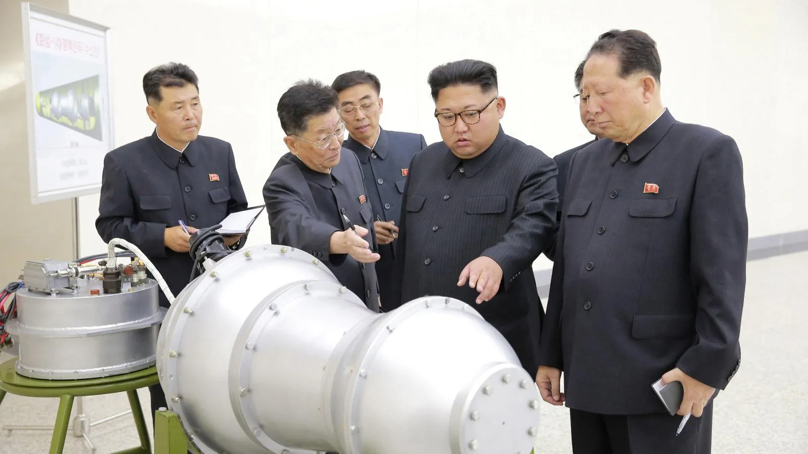 Kim Jong-Un looking at a nuclear warhead with military officials