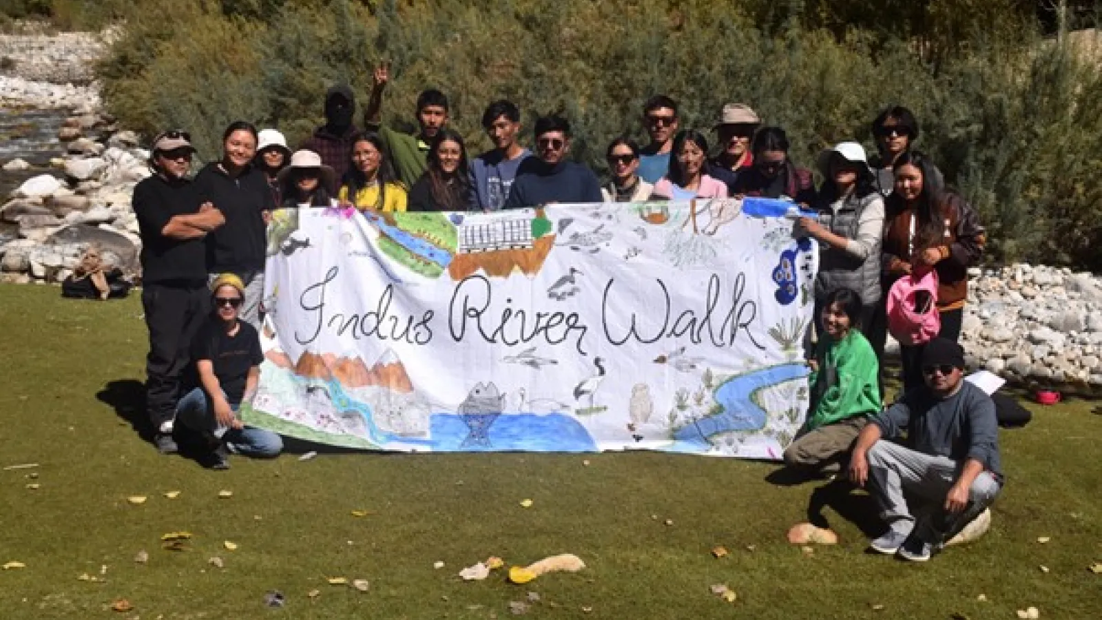 People holding sign reading Indus River Walk