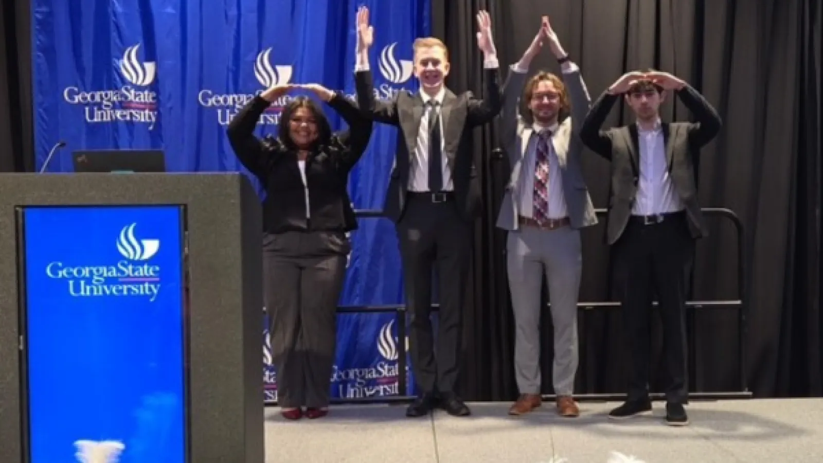 4 young people create O-H-I-O with their arms