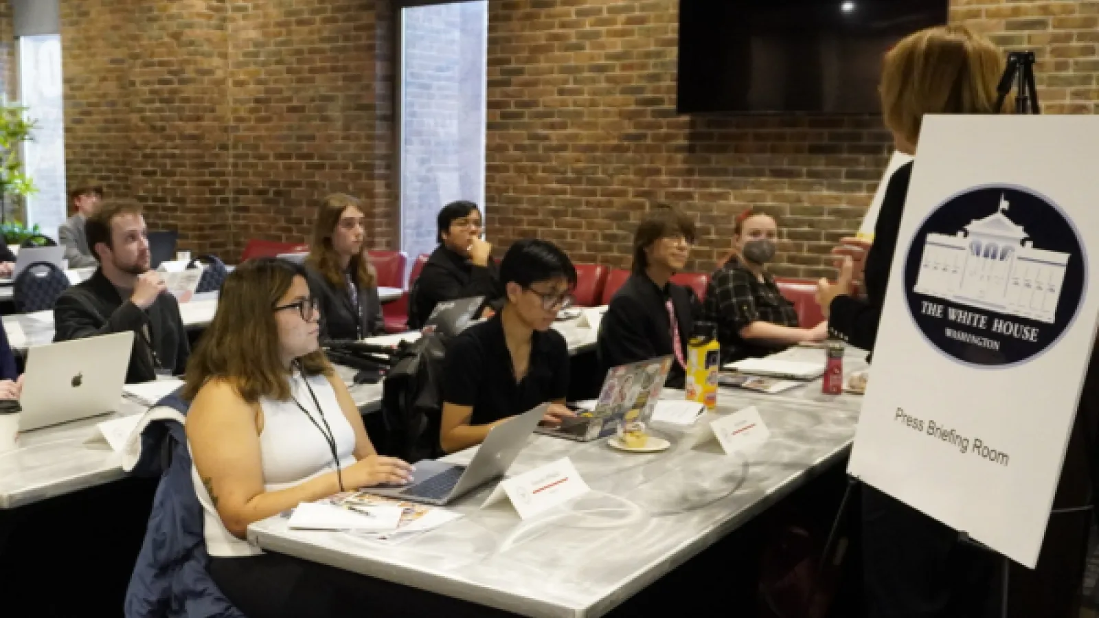 Reporters in a simulated white house press room