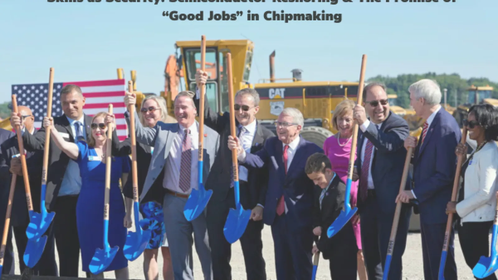 People smiling and raising shovels at construction site