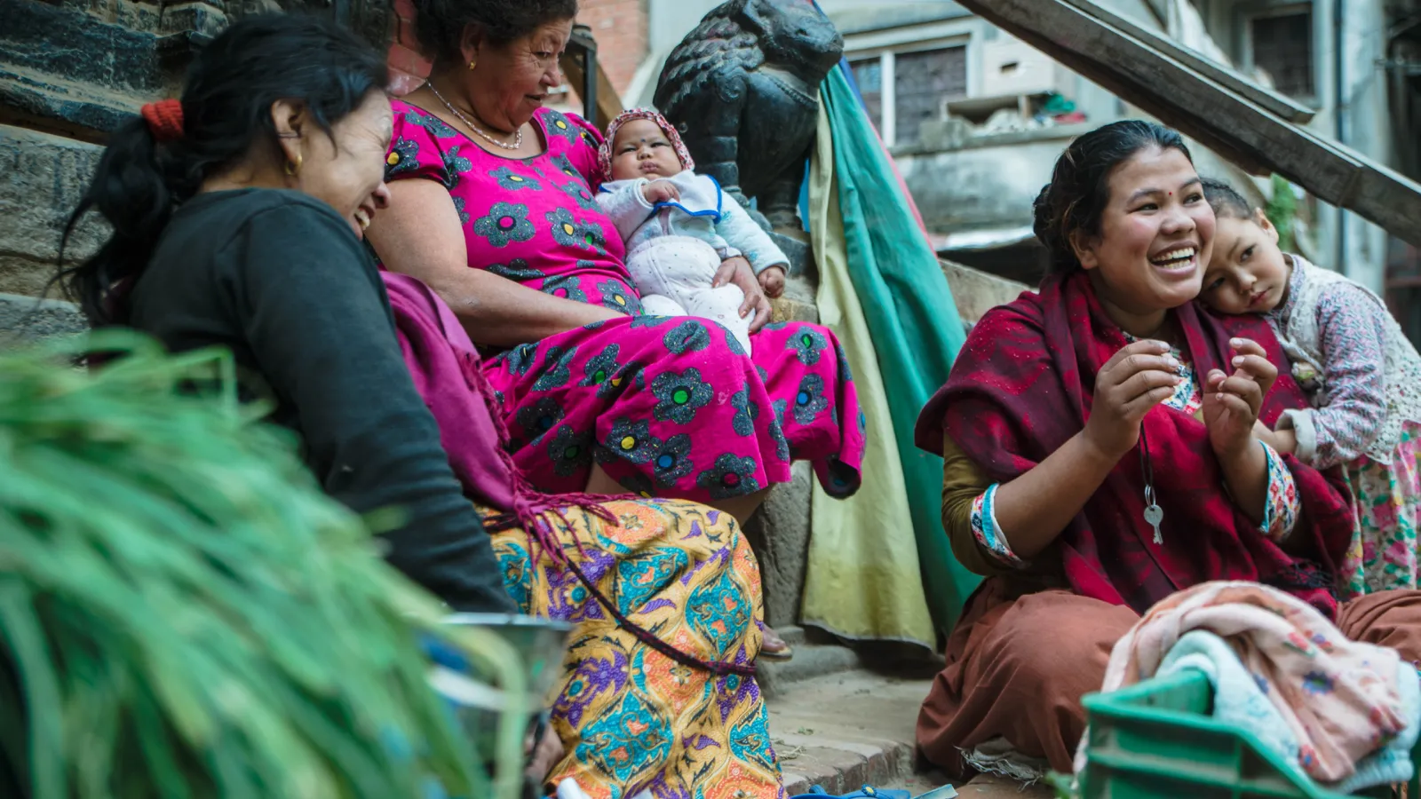 Women and children in Nepal laughing on outdoor staircase