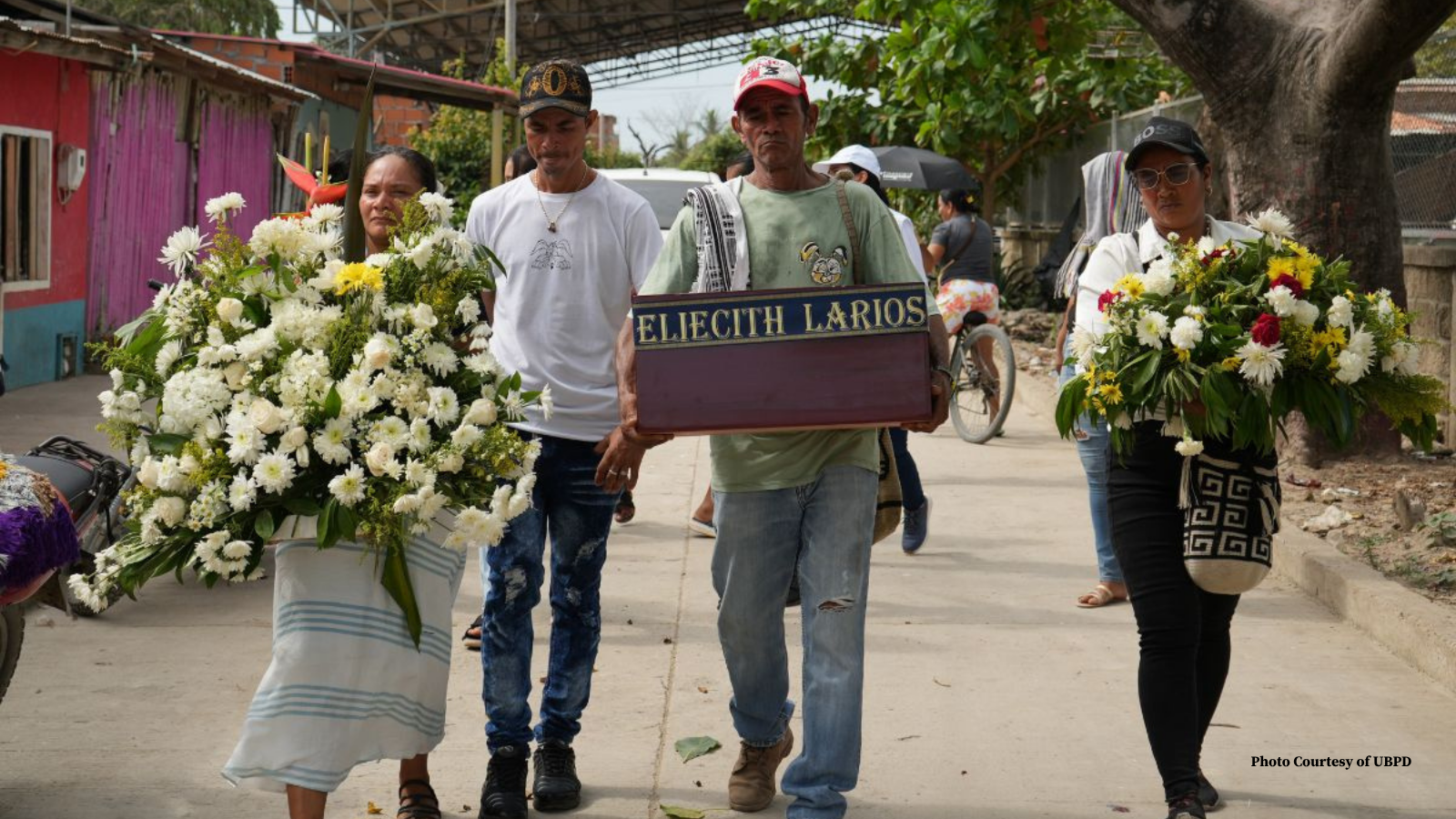Family of a Disappeared carrying a coffin with remains and flowers