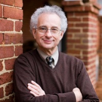 Mel Leffler leans against a brick wall