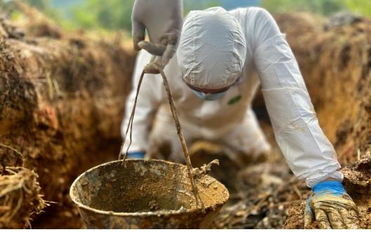 Forensic scientist exhuming remains