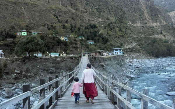 Mother and child crossing river on wooden bridge