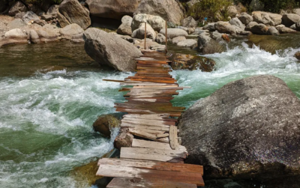 Wooden slats forming a bridge over a rolling river