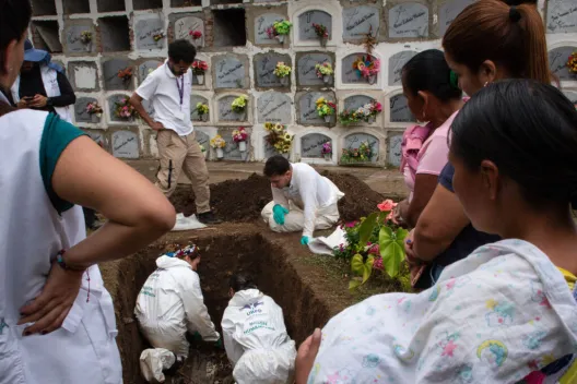 women searching grave with UBPD representatives