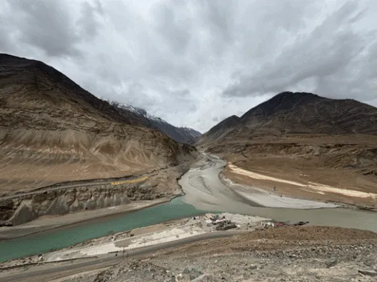 Confluence of two rivers below mountains