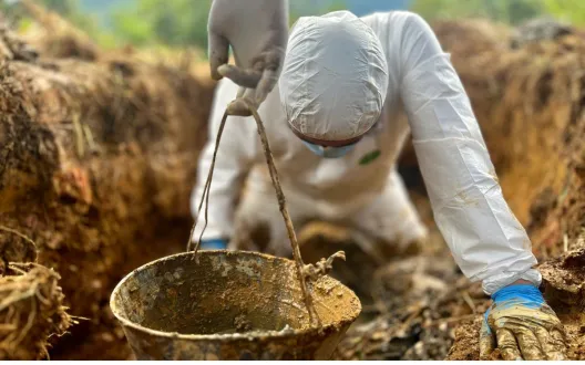 Forensic scientist exhuming remains
