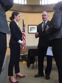 People conferring in room with flag