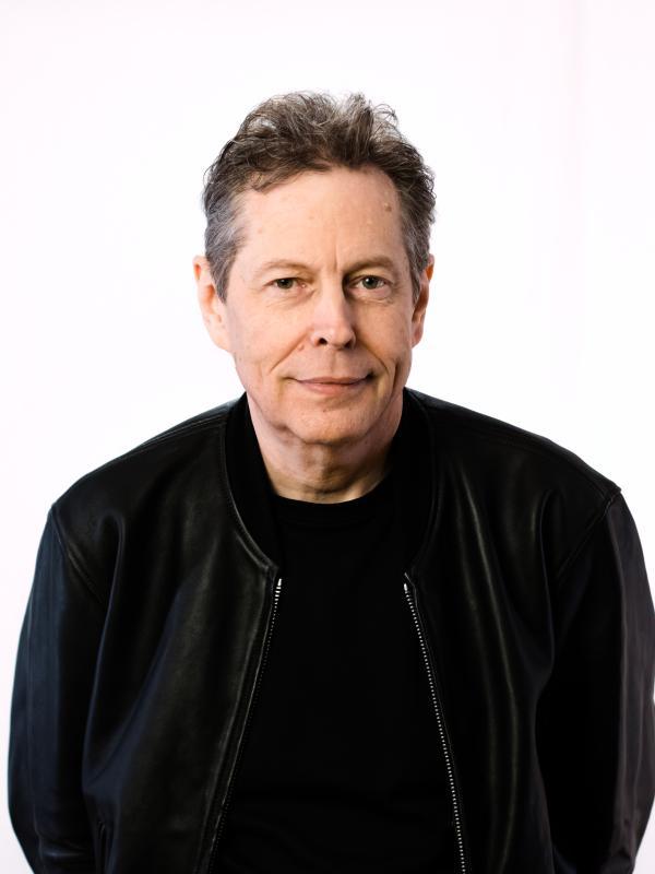 Alexander Wendt poses with a black t-shirt and black jacket on a white background.