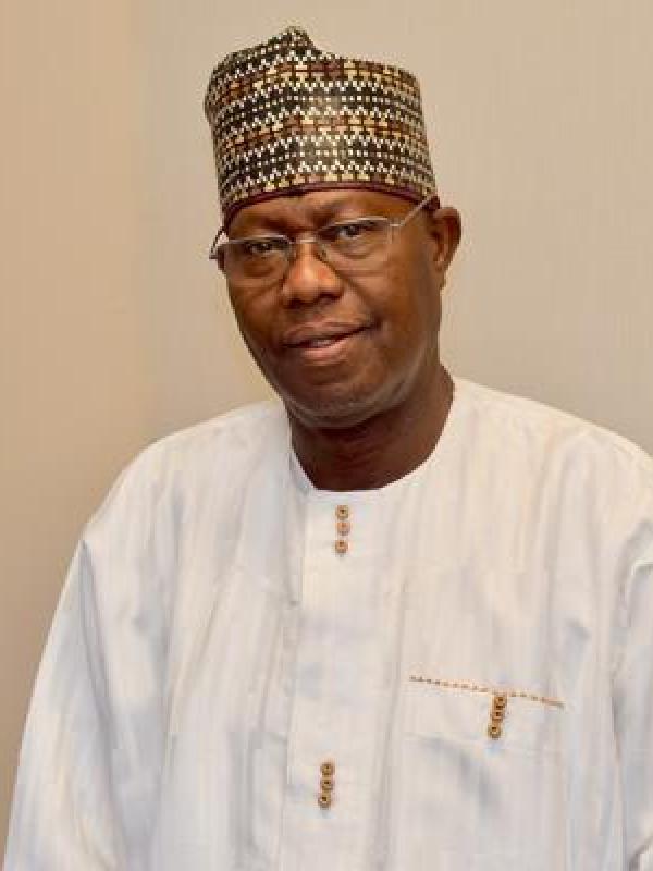 Ousman Kobo stands in front of a white background.