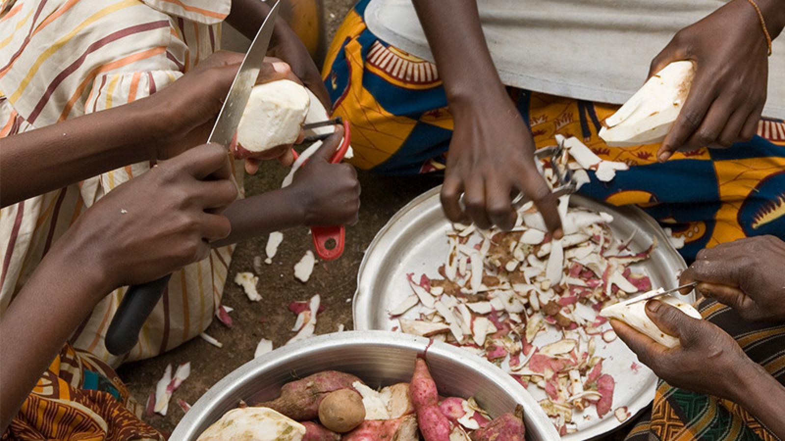 Burundi women peeling sweet potatos