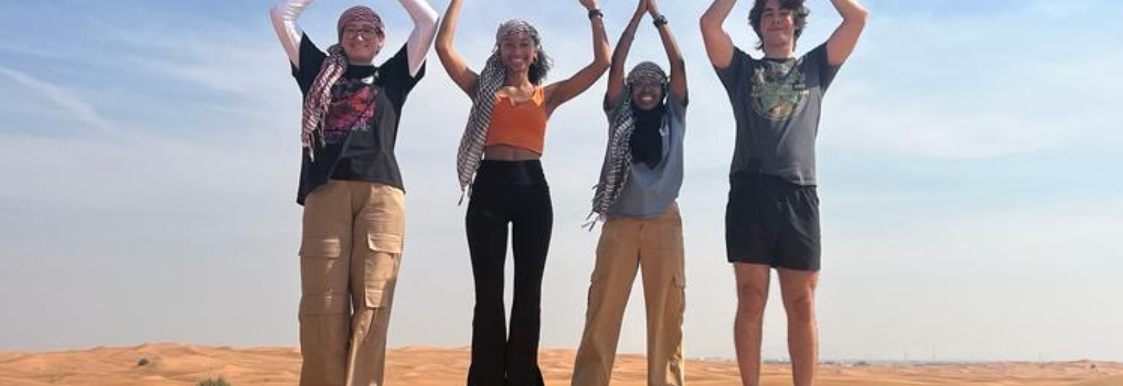 People in desert spelling out O-H-I-O with their arms
