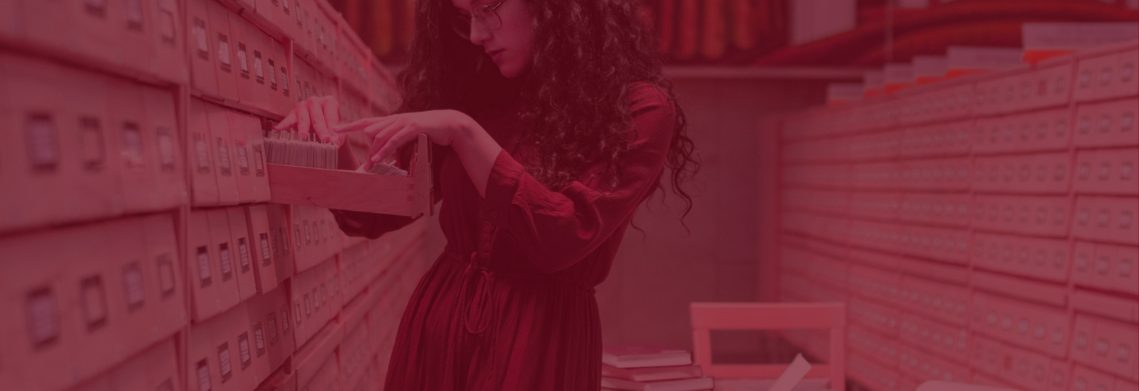 Woman looking in card catalogue in a library